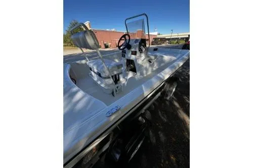 Slide: The Image of 2026 Mako Pro Skiff 17 CC boat with center console and seating, parked outdoors. - 7