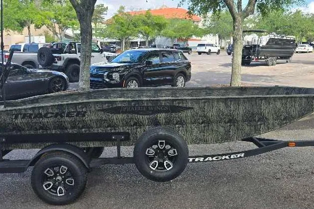 Slide: The Image of 2026 Tracker Grizzly 1650 T Prairie Wings Edition boat on trailer in parking lot. - 2