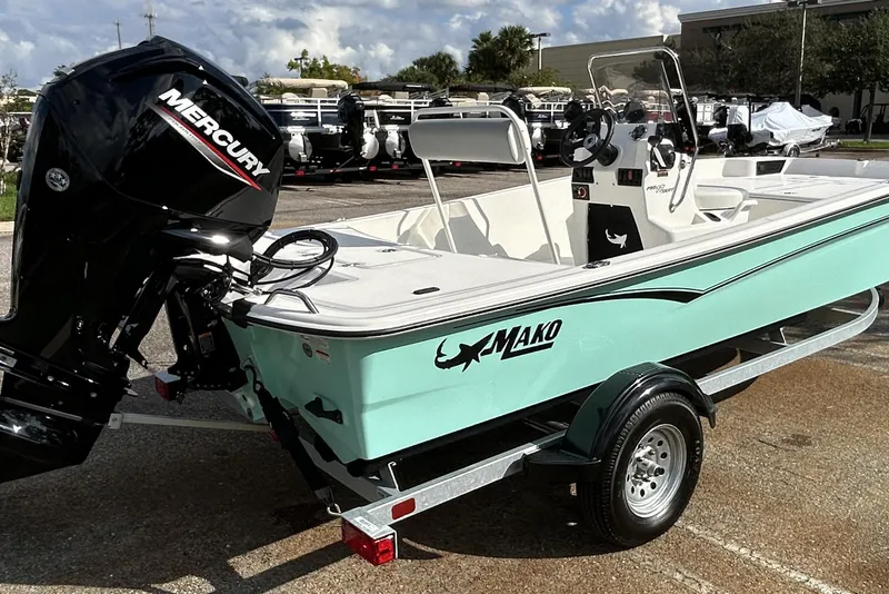 Slide: The Image of 2026 Mako Pro Skiff 17 CC boat with Mercury engine on trailer, parked outdoors. - 11