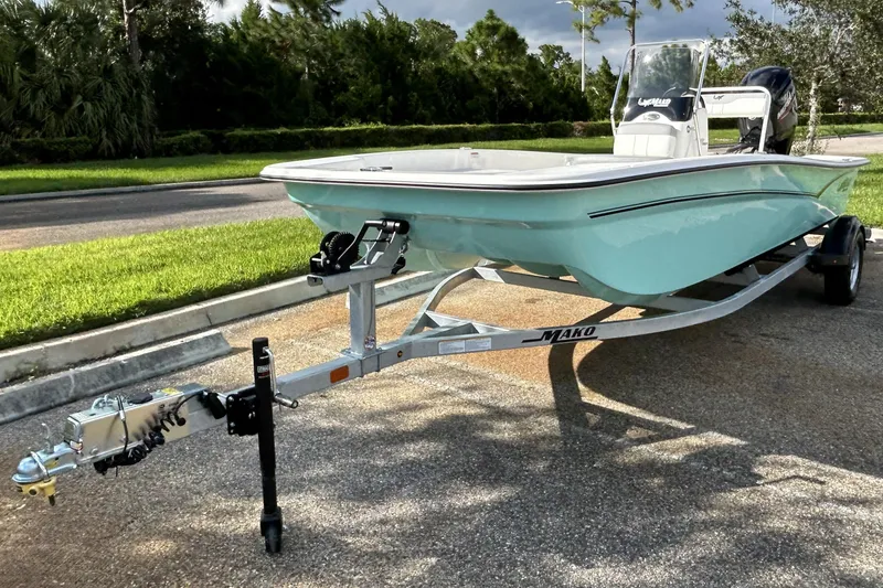 Slide: The Image of 2026 Mako Pro Skiff 17 CC boat on trailer, parked on a sunny street. - 3