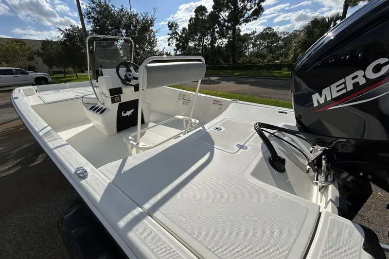 Slide: The Image of 2026 Mako Pro Skiff 17 CC boat with Mercury engine, parked outdoors. - 6