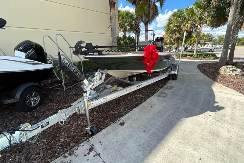 Slide: The Image of 2026 Mako 18 Pro Skiff Backwater Edition boat with red bow on trailer. - 2
