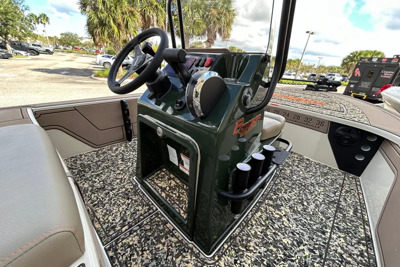 Slide: The Image of 2026 Mako 18 Pro Skiff Backwater Edition boat interior with steering console and rod holders. - 6