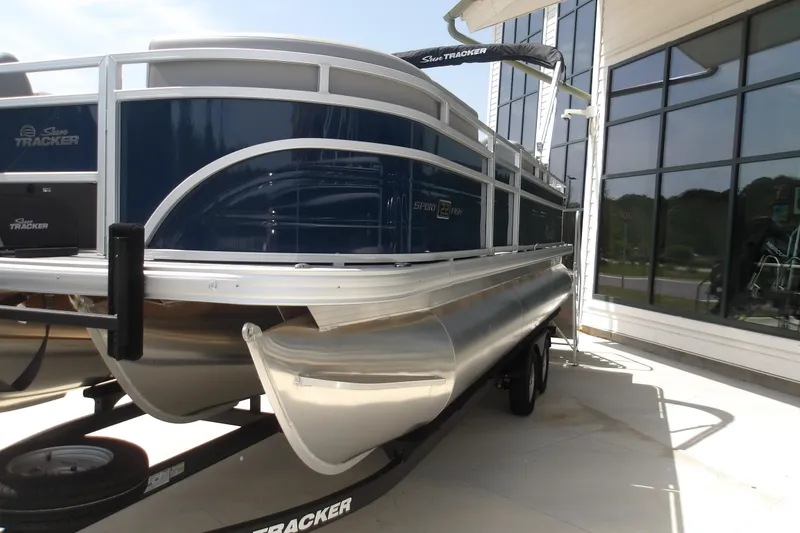 The Image of 2026 Sun Tracker SportFish 22 XP3 pontoon boat on trailer, parked near a building. - 33