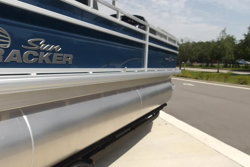 Slide: The Image of 2026 Sun Tracker SportFish 22 XP3 pontoon boat, blue exterior, parked on pavement. - 37