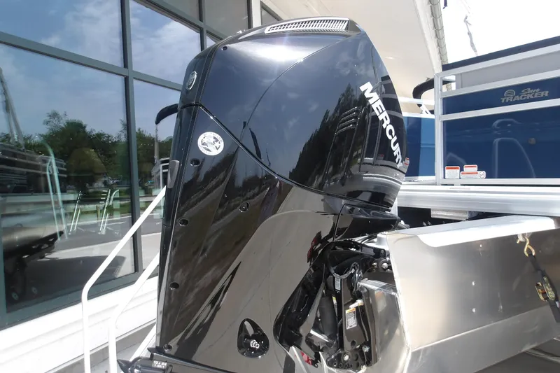 Slide: The Image of 2026 Sun Tracker SportFish 22 XP3 with Mercury outboard motor, docked near glass building. - 40