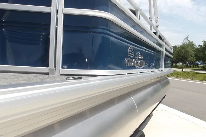 Slide: The Image of 2026 Sun Tracker SportFish 22 XP3 pontoon boat, blue exterior, parked outdoors. - 38
