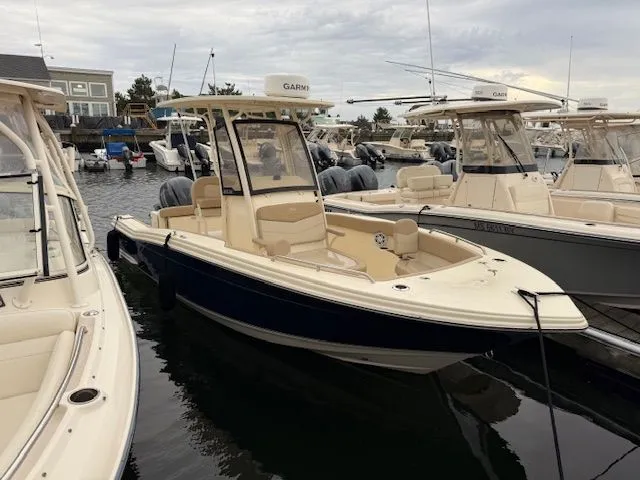 Slide: The Image of 2023 Scout 215 XSF boat docked in a marina, surrounded by other boats. - 1