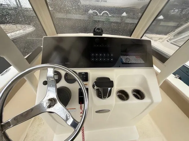 Slide: The Image of 2023 Scout 215 XSF boat dashboard with steering wheel and controls. - 10