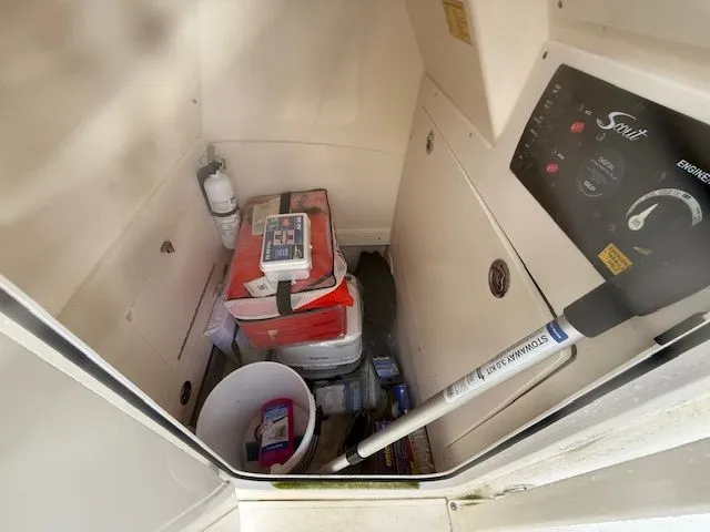 Slide: The Image of 2023 Scout 215 XSF boat storage area with safety equipment and supplies. - 11