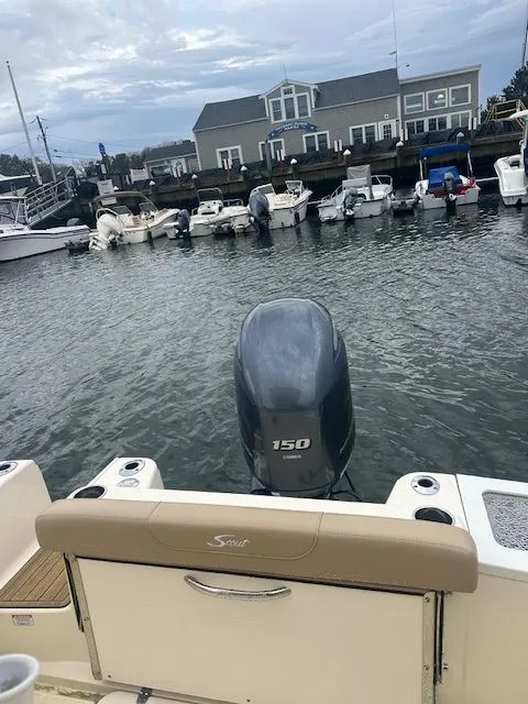 Slide: The Image of 2023 Scout 215 XSF boat with 150 HP engine docked in a marina. - 5