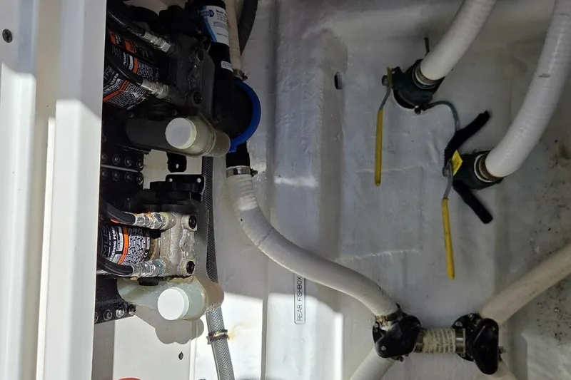 Slide: The Image of Engine compartment of 2020 Invincible 35 Catamaran with visible hoses and valves. - 16