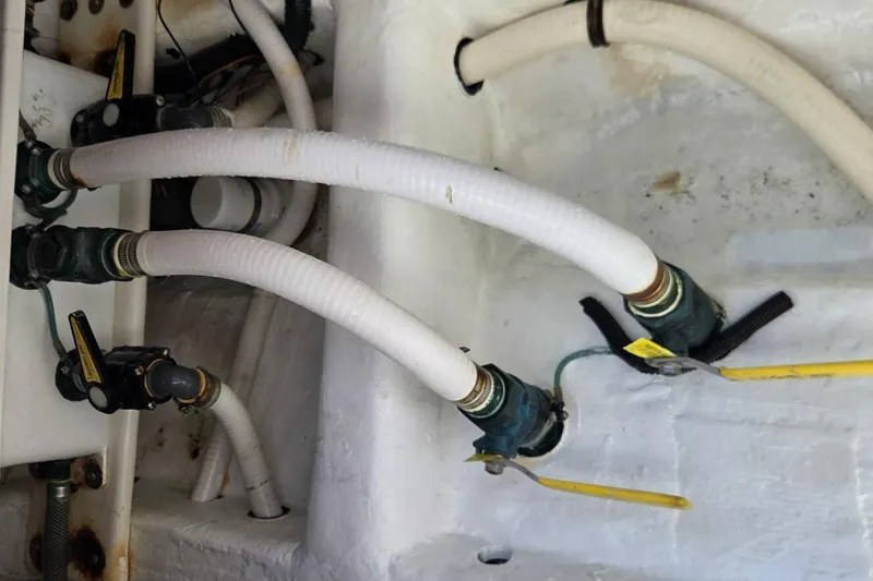 Slide: The Image of Engine compartment of 2020 Invincible 35 Catamaran with hoses and valves. - 18