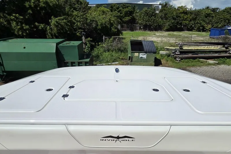 Slide: The Image of 2020 Invincible 35 Catamaran deck view with storage compartments, surrounded by greenery. - 8