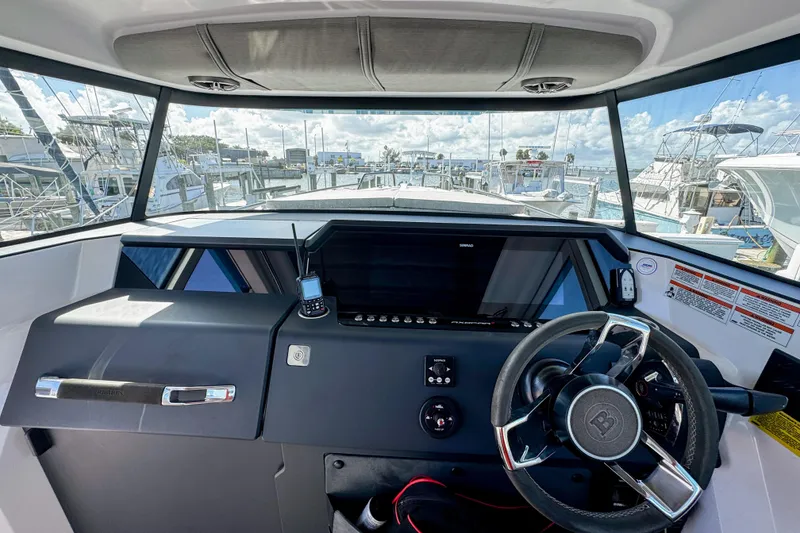 Slide: The Image of 2024 Axopar 37XC CROSS CABIN helm with steering wheel and navigation equipment. - 11