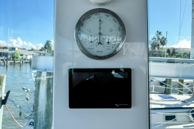 Slide: The Image of Barometer and display inside 2024 Axopar 37XC CROSS CABIN, with marina view. - 12