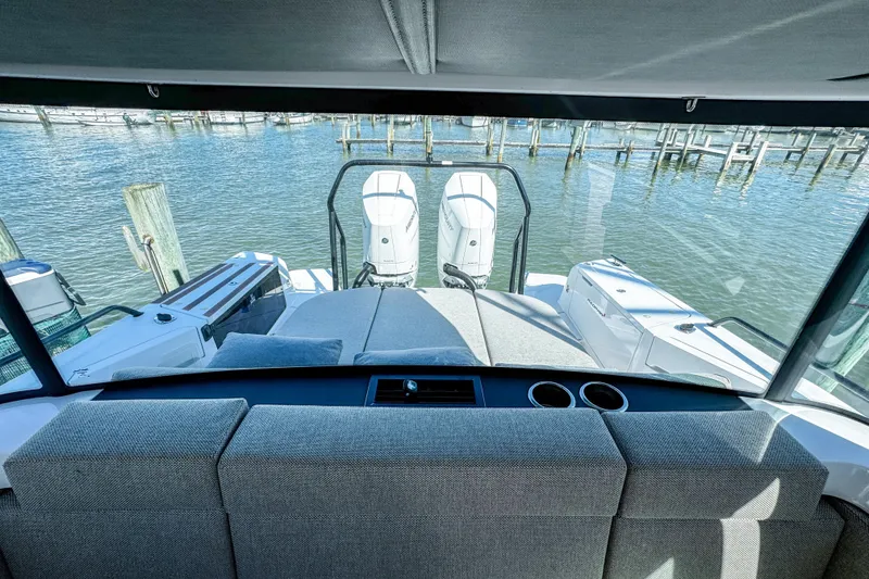 Slide: The Image of 2024 Axopar 37XC CROSS CABIN interior view with water and dock in background. - 14