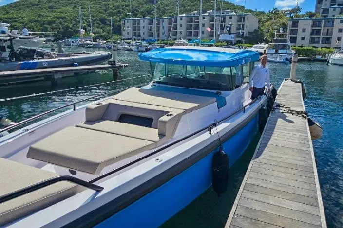 Slide: The Image of 2024 Axopar 37XC CROSS CABIN docked at marina, featuring sleek design and spacious deck. - 2