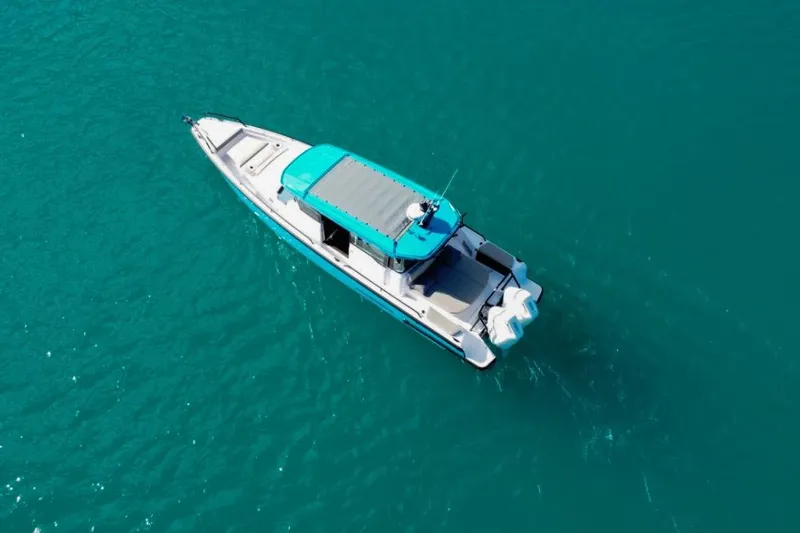Slide: The Image of 2024 Axopar 37XC CROSS CABIN boat on clear turquoise water. - 24