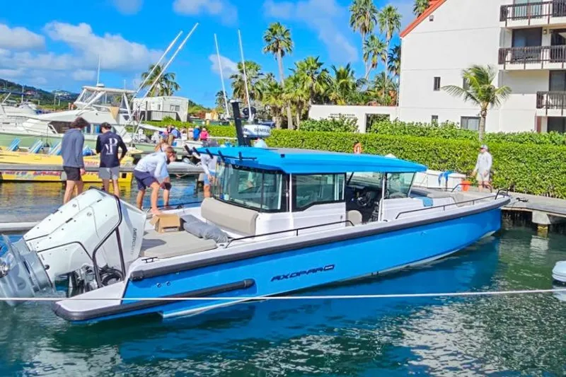 Slide: The Image of 2024 Axopar 37XC CROSS CABIN boat docked in a marina with people nearby. - 3