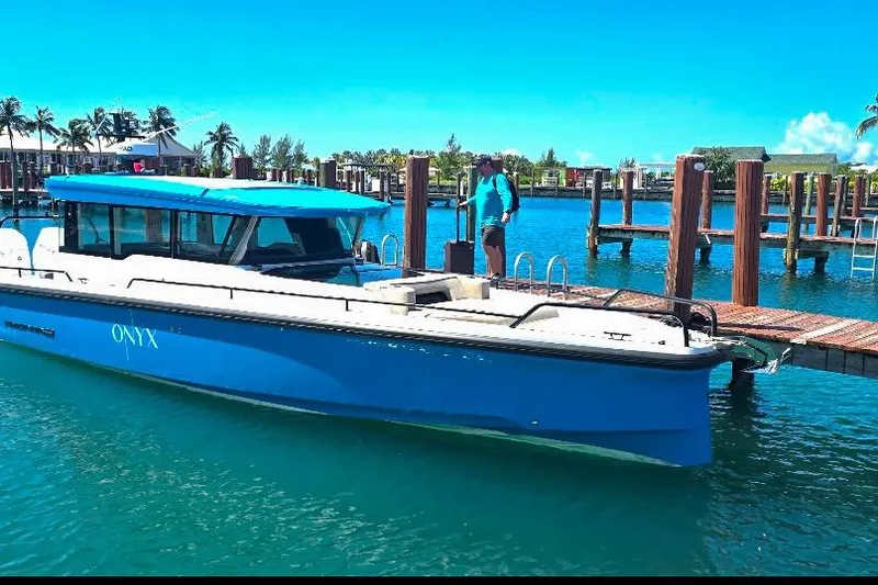 Slide: The Image of 2024 Axopar 37XC CROSS CABIN boat docked in a sunny marina setting. - 4