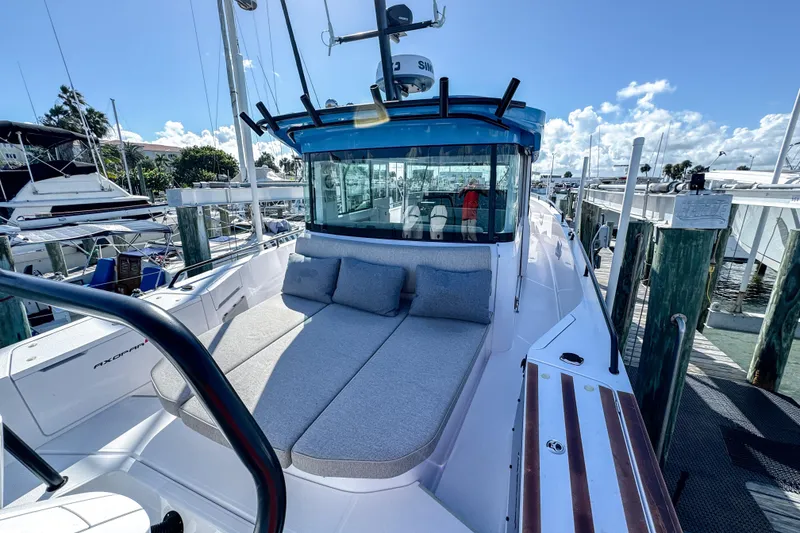 Slide: The Image of 2024 Axopar 37XC CROSS CABIN boat docked, featuring spacious sunbed and modern design. - 7