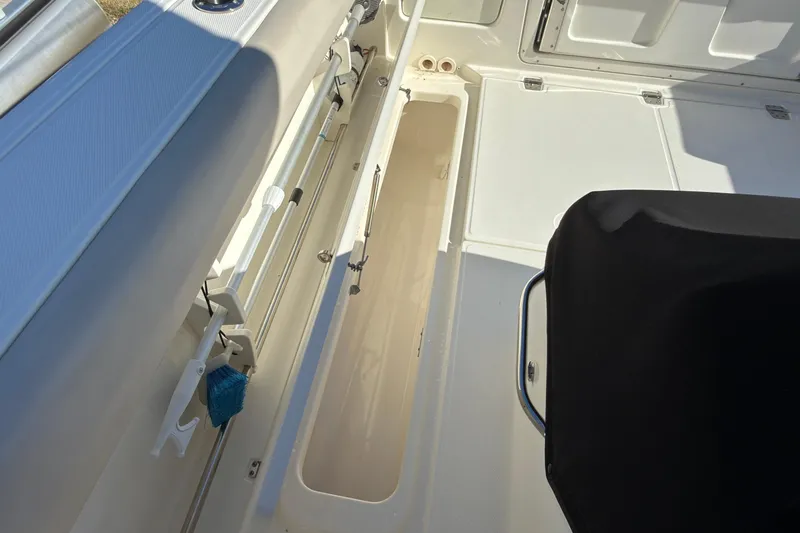 Slide: The Image of 2016 Boston Whaler 330 Outrage interior storage compartment with cleaning tools. - 13