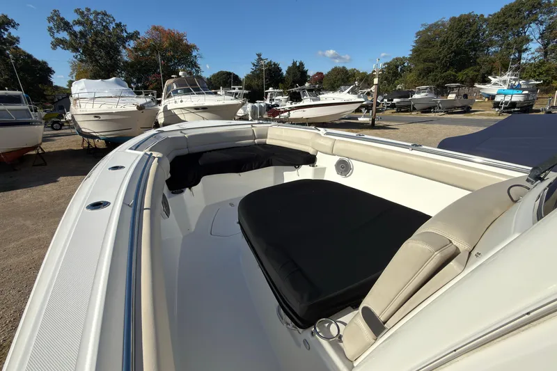 Slide: The Image of 2016 Boston Whaler 330 Outrage boat, spacious deck, parked among other boats. - 9