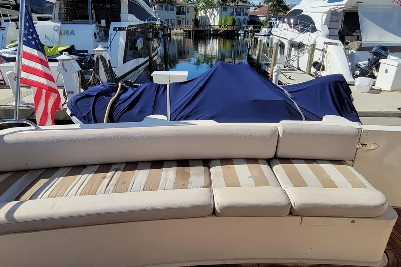 Slide: The Image of 1998 Viking Princess 50 Sport Cruiser with striped seating, docked near other boats. - 12