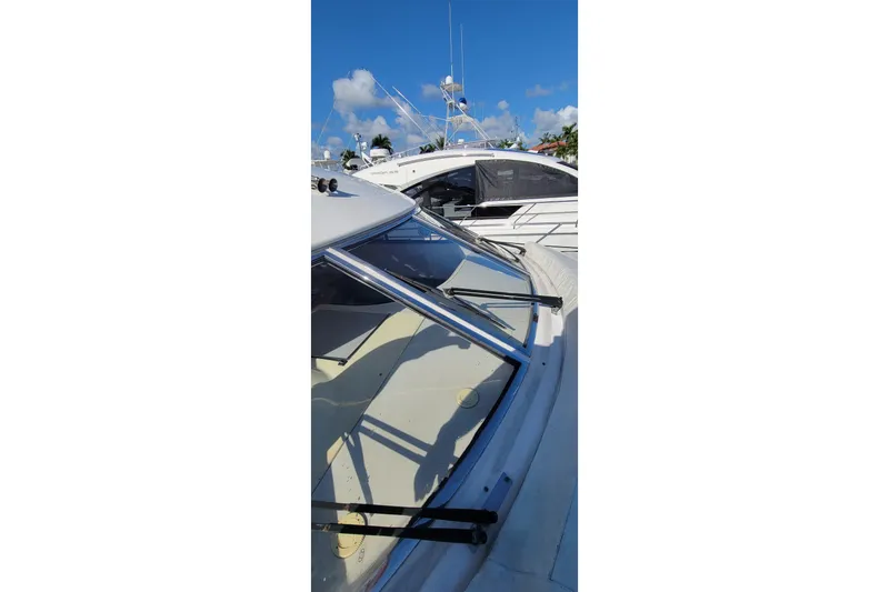 Slide: The Image of 1998 Viking Princess 50 Sport Cruiser with spacious seating and helm, docked at marina. - 15