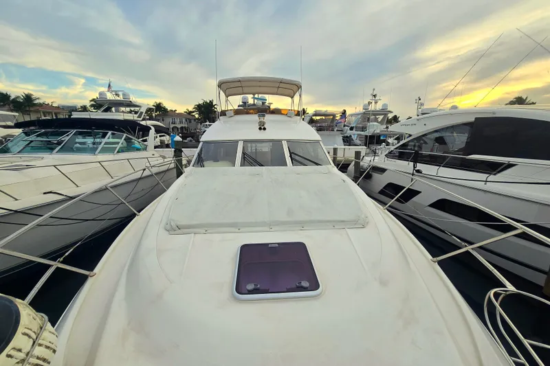 Slide: The Image of 1998 Viking Princess 50 Sport Cruiser docked among luxury yachts at sunset. - 42