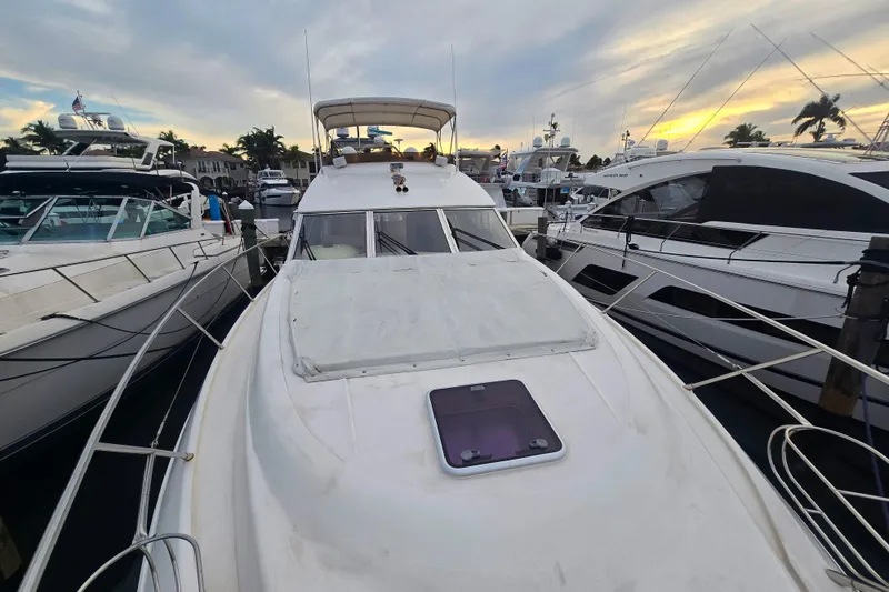 Slide: The Image of 1998 Viking Princess 50 Sport Cruiser docked at marina during sunset. - 43