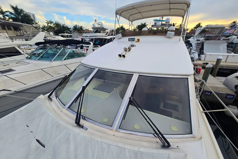 Slide: The Image of 1998 Viking Princess 50 Sport Cruiser docked at marina, surrounded by other boats. - 44