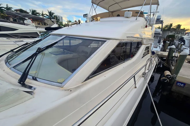 Slide: The Image of 1998 Viking Princess 50 Sport Cruiser docked at marina, showcasing sleek design and spacious deck. - 45