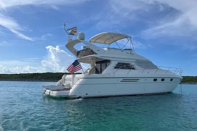 Slide: The Image of 1998 Viking Princess 50 Sport Cruiser yacht on calm blue water under clear sky. - 57