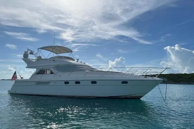 Slide: The Image of 1998 Viking Princess 50 Sport Cruiser yacht on calm waters under a blue sky. - 58