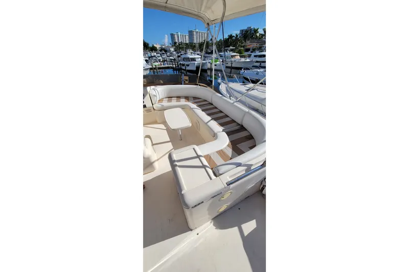 Slide: The Image of 1998 Viking Princess 50 Sport Cruiser deck with striped seating and stairs. - 9