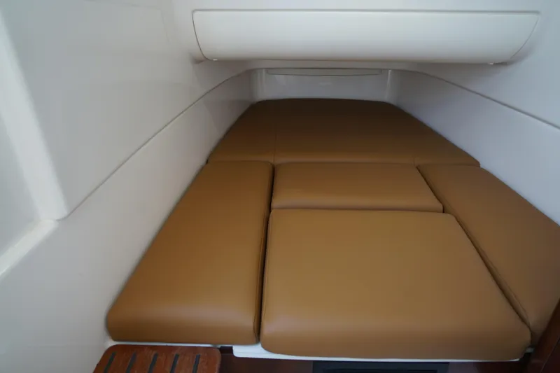Slide: The Image of 2024 Robalo R360 Center Console cabin with brown cushioned seating. - 21