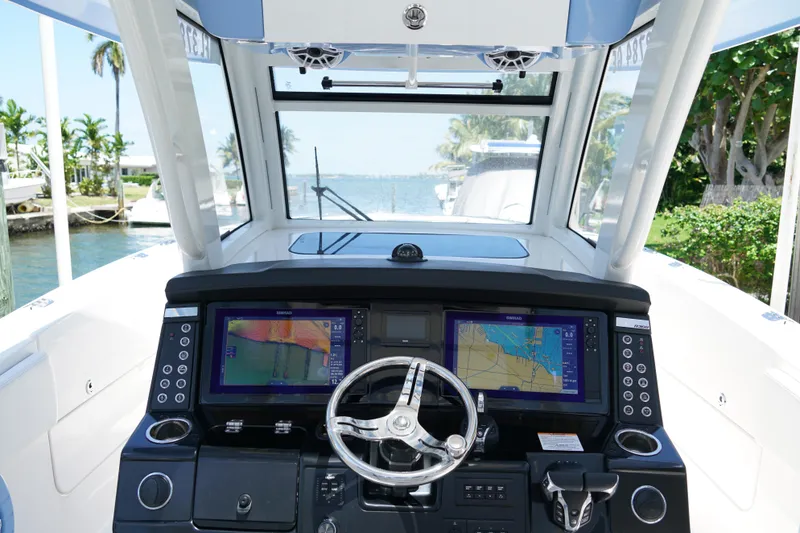 Slide: The Image of 2024 Robalo R360 Center Console boat helm with dual navigation screens and steering wheel. - 26