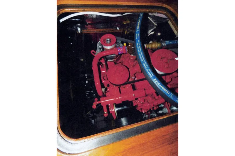Slide: The Image of Engine compartment of a 1983 Beneteau First 38.5 sailboat, featuring a red engine. - 11
