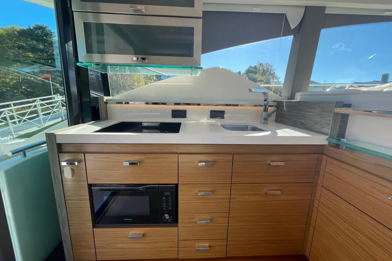 Slide: The Image of Modern kitchen interior on a 2020 Tiara 53C yacht, featuring sleek cabinetry and appliances. - 13