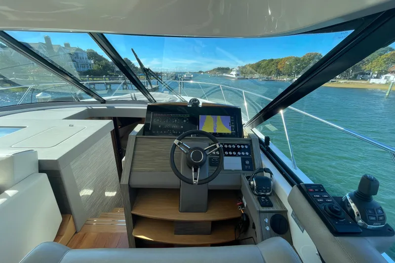 Slide: The Image of Cockpit view of 2020 Tiara 53C yacht, featuring modern navigation controls and scenic waterfront. - 19