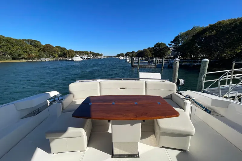 Slide: The Image of Luxury Tiara 53C yacht interior with elegant seating and table, docked in a scenic marina. - 22