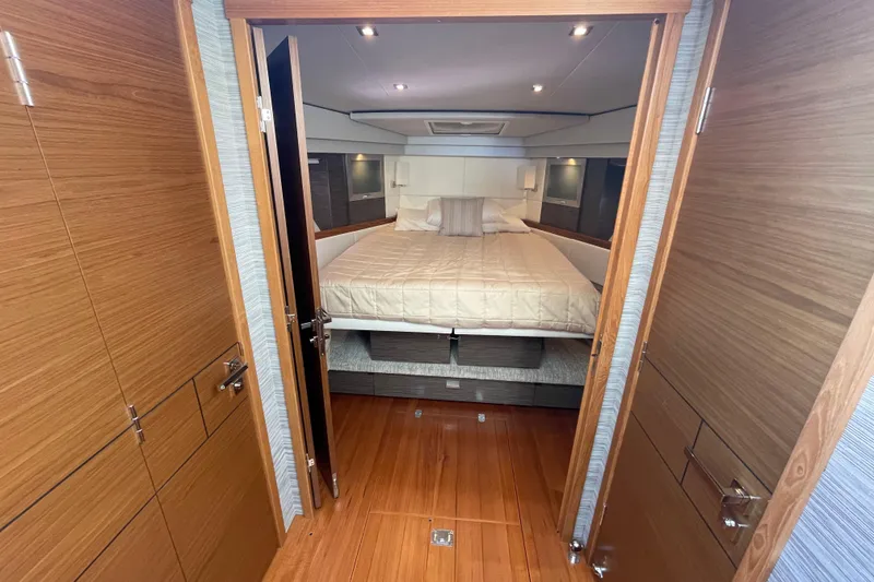Slide: The Image of Luxurious bedroom interior of 2020 Tiara 53C yacht with wooden finishes and cozy bedding. - 23