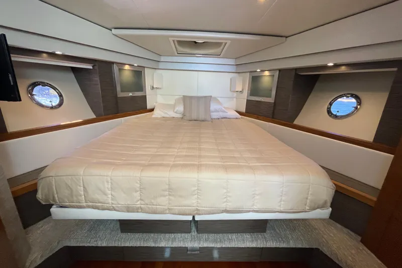Slide: The Image of Luxurious bedroom interior of 2020 Tiara 53C yacht with elegant bedding and porthole windows. - 24
