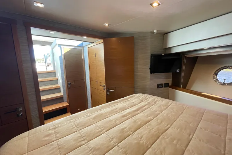 Slide: The Image of Luxurious interior of 2020 Tiara 53C yacht cabin with bed, stairs, and porthole window. - 25