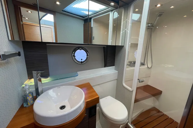 Slide: The Image of Luxurious bathroom in 2020 Tiara 53C yacht with modern fixtures and porthole window. - 27