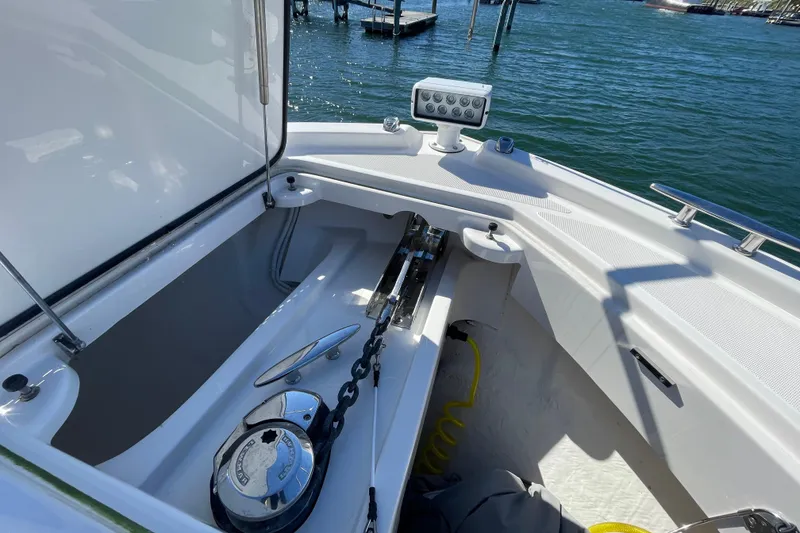 Slide: The Image of 2020 Tiara 53C boat anchor compartment with chain and winch, docked on calm water. - 5