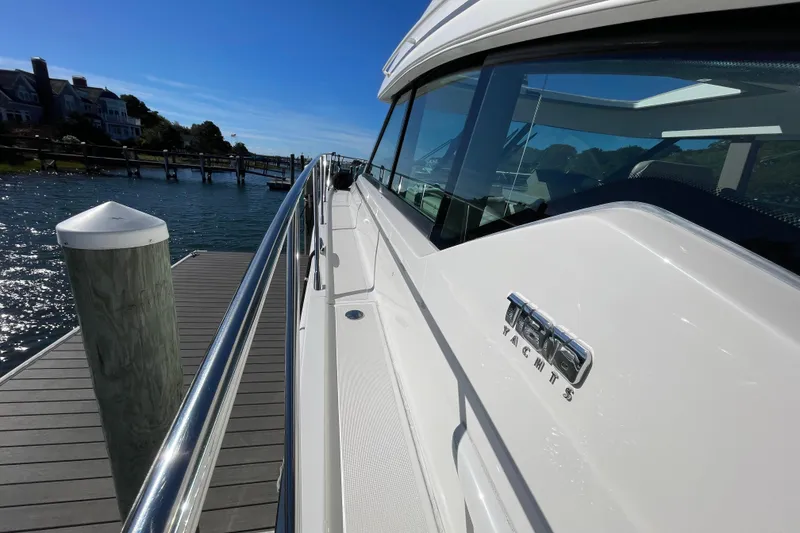 Slide: The Image of 2020 Tiara 53C yacht docked at a marina under clear blue skies. - 6