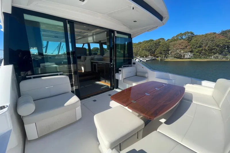 Slide: The Image of Luxurious 2020 Tiara 53C yacht with elegant outdoor seating and scenic water view. - 9